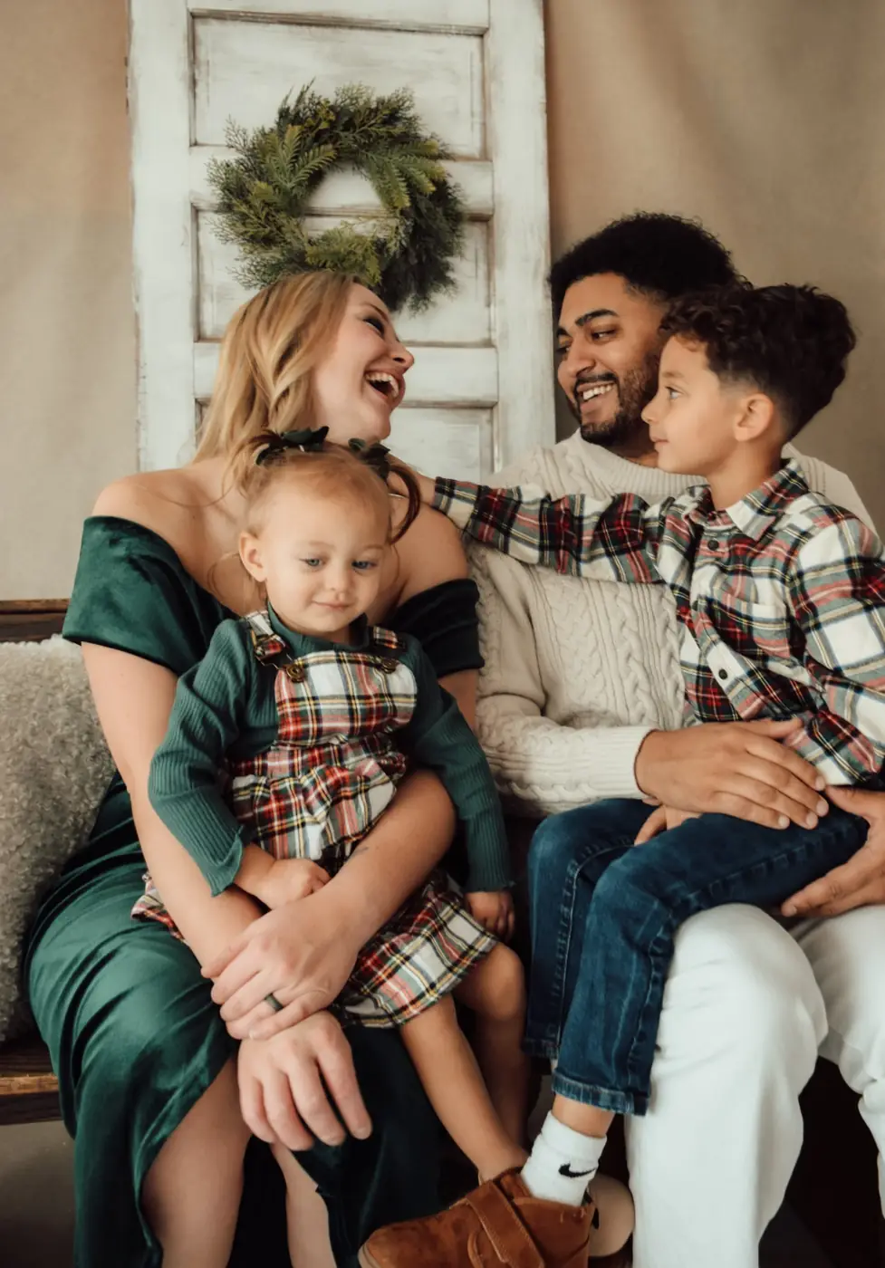 Family in green and plaid laughing together for holiday photos