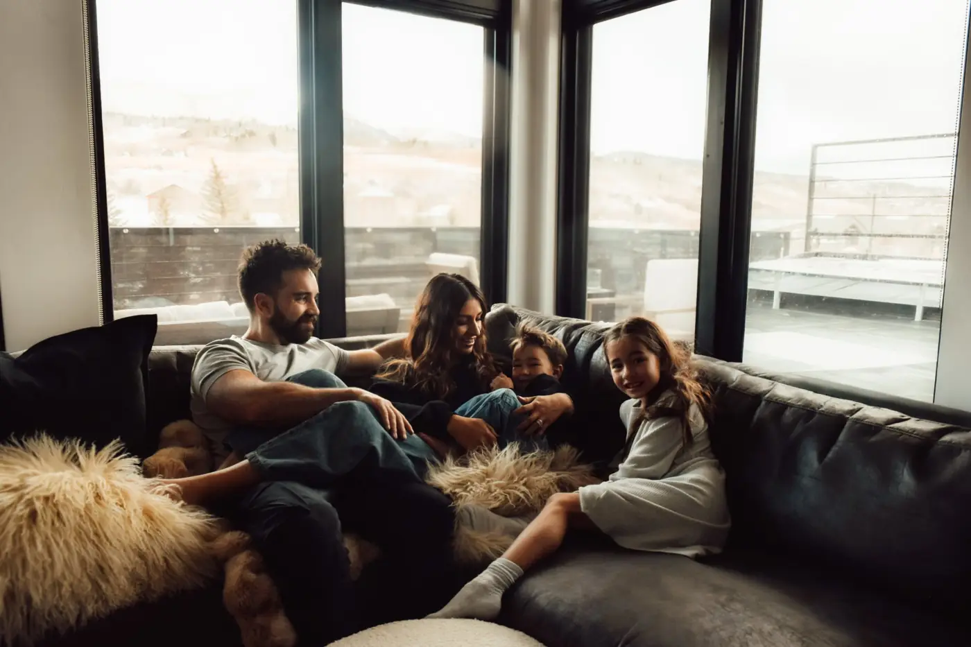 Family laughing together on a couch with mountain views